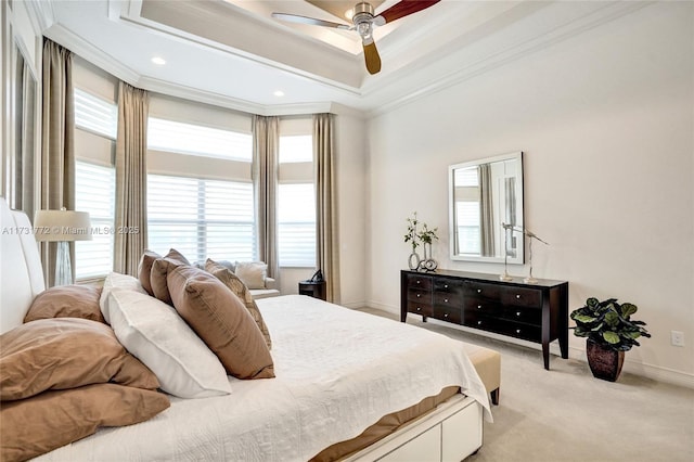 bedroom with ceiling fan, light colored carpet, ornamental molding, and a raised ceiling