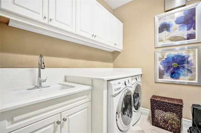 clothes washing area featuring cabinets, sink, and independent washer and dryer