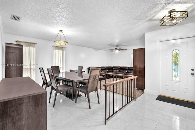 dining area featuring a textured ceiling and a healthy amount of sunlight