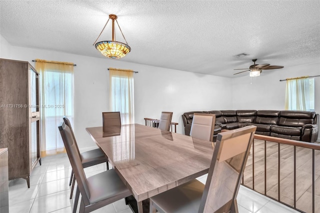 dining area with light tile patterned floors, a textured ceiling, and ceiling fan