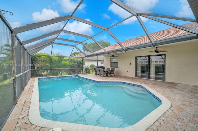 view of swimming pool featuring ceiling fan, a patio, and glass enclosure