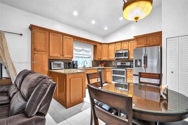 kitchen with vaulted ceiling, sink, decorative backsplash, a center island, and stainless steel appliances