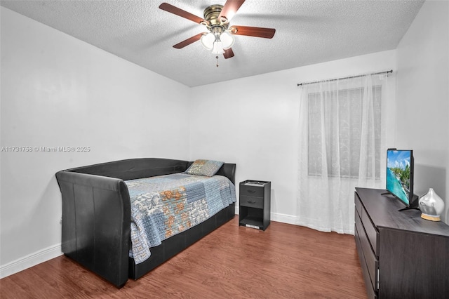 bedroom with dark hardwood / wood-style flooring, a textured ceiling, and ceiling fan