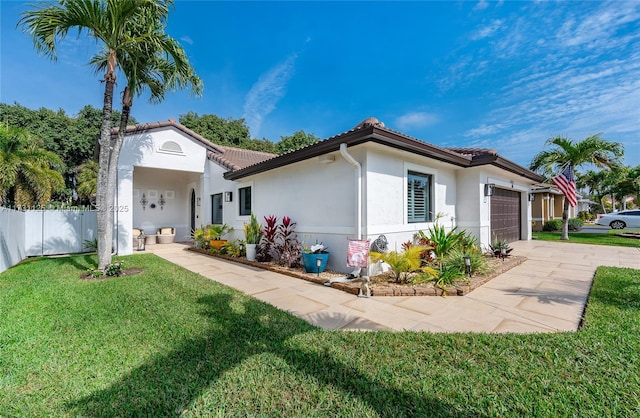 mediterranean / spanish-style house with a garage and a front lawn