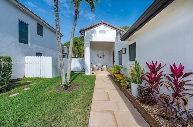 view of exterior entry with a lawn