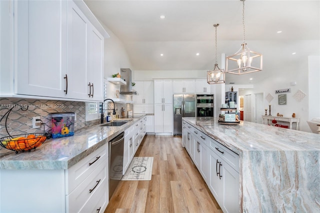 kitchen with a large island, appliances with stainless steel finishes, tasteful backsplash, a sink, and white cabinets