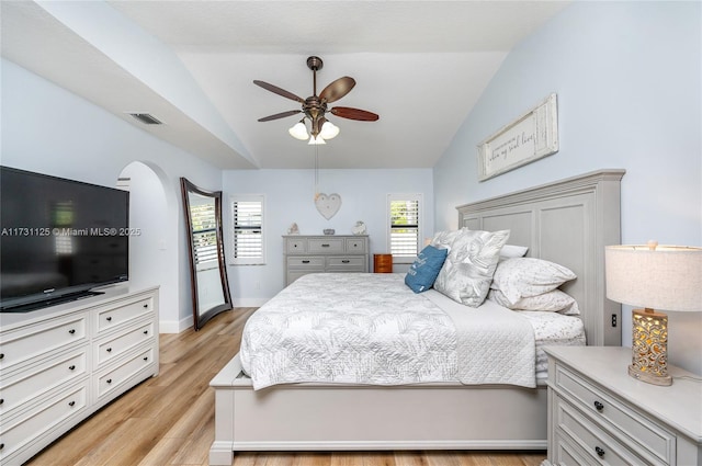 bedroom with visible vents, baseboards, ceiling fan, light wood finished floors, and vaulted ceiling