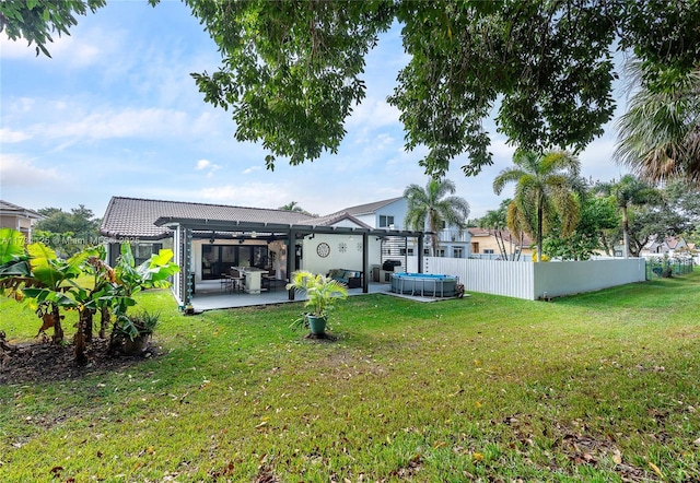 back of property with a patio area, fence, a yard, a pergola, and a jacuzzi