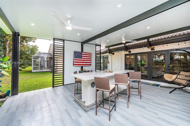 exterior space featuring ceiling fan, wood finished floors, and a wealth of natural light