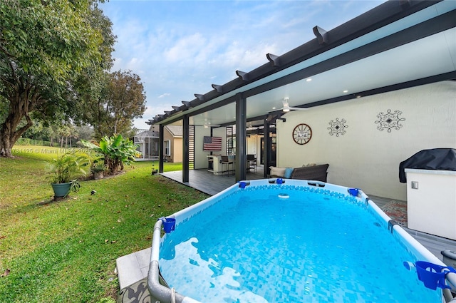 view of pool featuring ceiling fan and a lawn