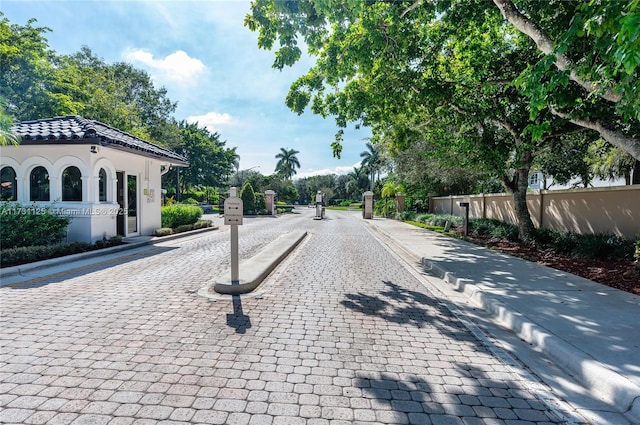 view of road with curbs and a gated entry