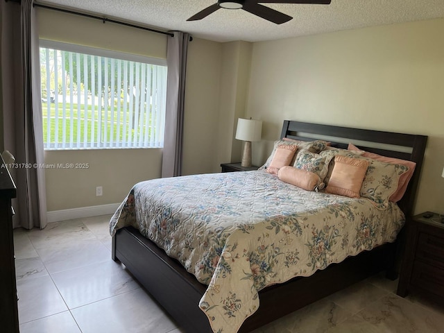 tiled bedroom featuring a textured ceiling and ceiling fan