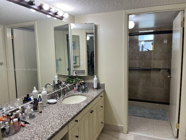 bathroom with a shower with door, vanity, tile patterned flooring, and a textured ceiling