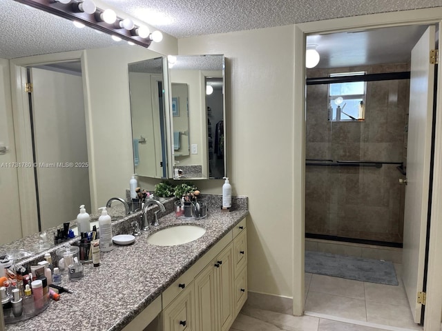 bathroom featuring tile patterned flooring, vanity, a textured ceiling, and a shower with shower door