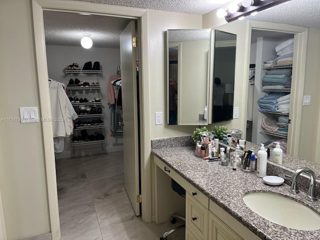 bathroom featuring tile patterned floors, vanity, and a textured ceiling