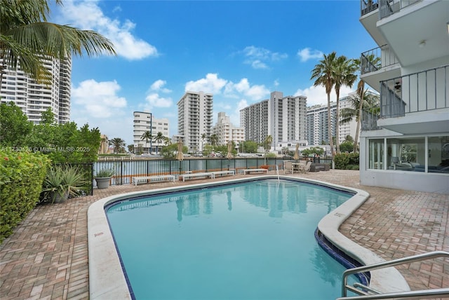 view of pool featuring a patio area and a water view