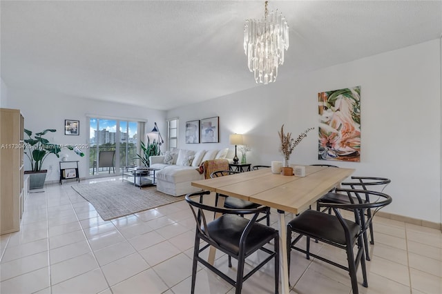 dining area with an inviting chandelier, light tile patterned floors, and a textured ceiling