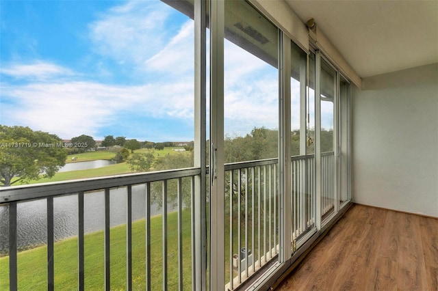 unfurnished sunroom featuring a water view