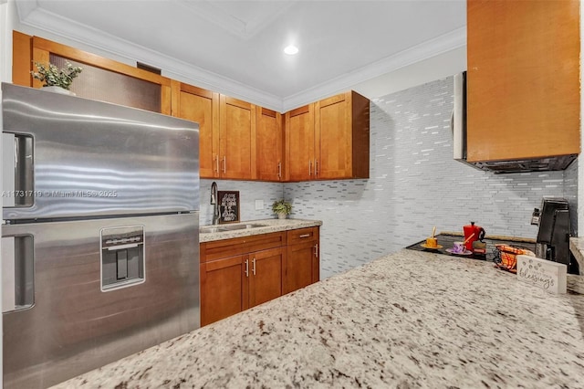 kitchen with ornamental molding, sink, light stone countertops, and stainless steel fridge with ice dispenser