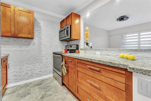 kitchen with ornamental molding, appliances with stainless steel finishes, and light stone countertops