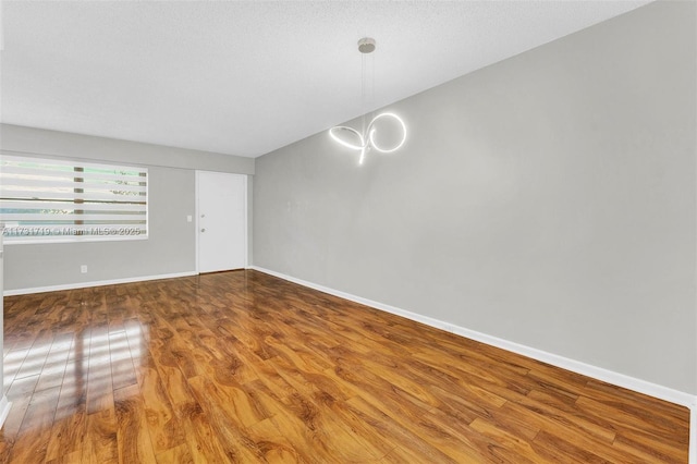 unfurnished room featuring hardwood / wood-style floors and a textured ceiling