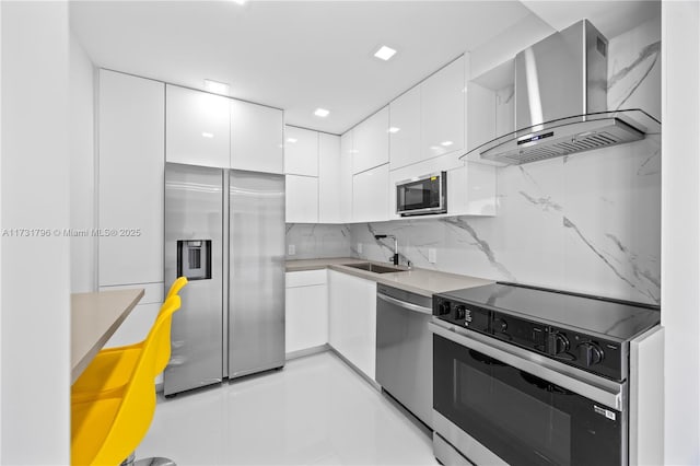 kitchen with sink, appliances with stainless steel finishes, white cabinetry, tasteful backsplash, and ventilation hood