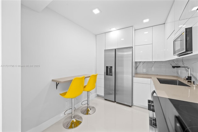 kitchen with stainless steel fridge with ice dispenser, backsplash, sink, and white cabinets