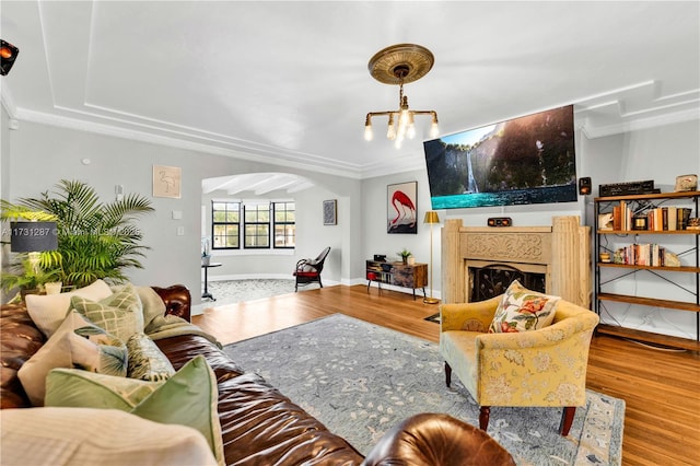 living room featuring ornamental molding, a chandelier, and light wood-type flooring