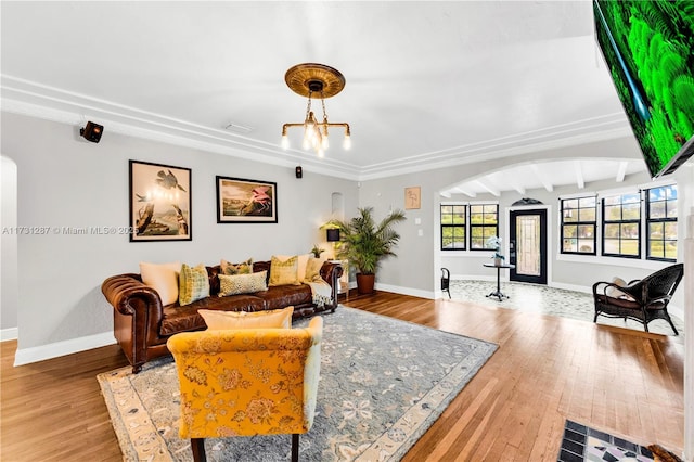 living room featuring a notable chandelier, beam ceiling, and hardwood / wood-style flooring