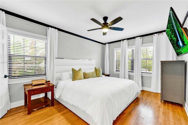 bedroom with crown molding, ceiling fan, and hardwood / wood-style floors