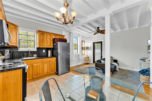 kitchen featuring sink, light tile patterned floors, plenty of natural light, and appliances with stainless steel finishes