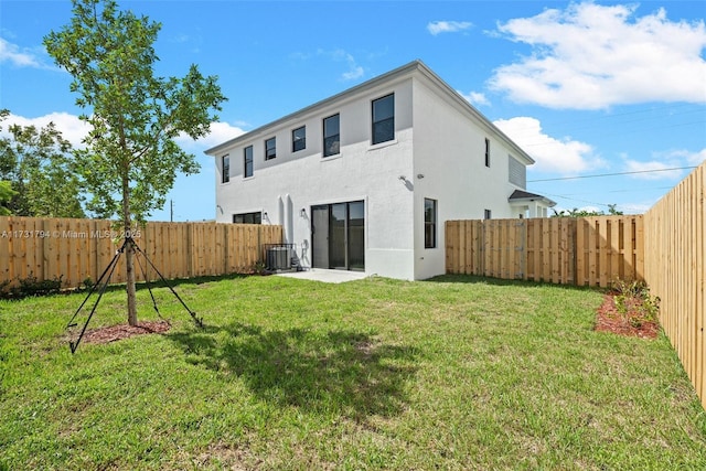 back of property featuring central AC unit and a lawn