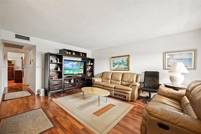 living room featuring dark hardwood / wood-style flooring and a textured ceiling