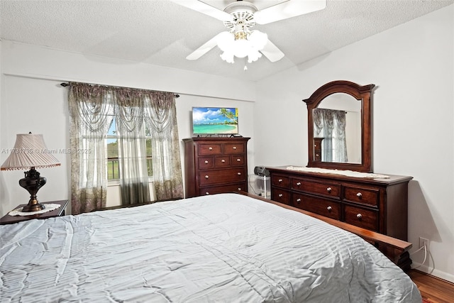 bedroom with a textured ceiling, wood-type flooring, and ceiling fan