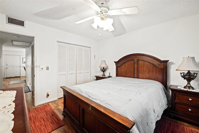 bedroom featuring hardwood / wood-style floors, a textured ceiling, ceiling fan, and a closet