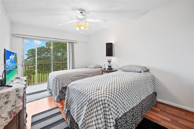 bedroom featuring ceiling fan, wood-type flooring, access to exterior, and a textured ceiling