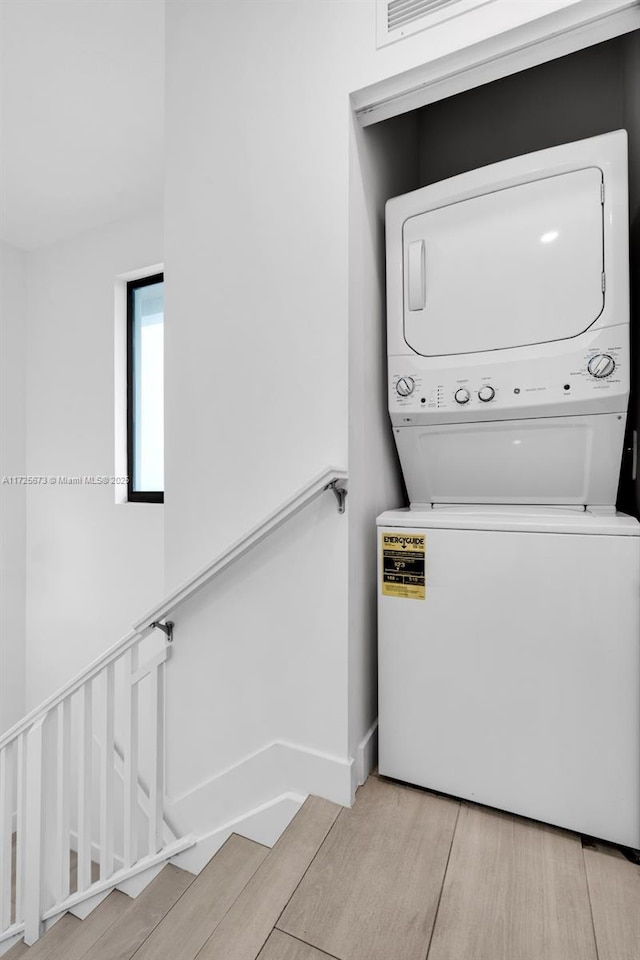 laundry area featuring stacked washer / dryer