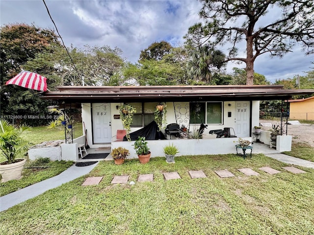 ranch-style house featuring a porch and a front yard