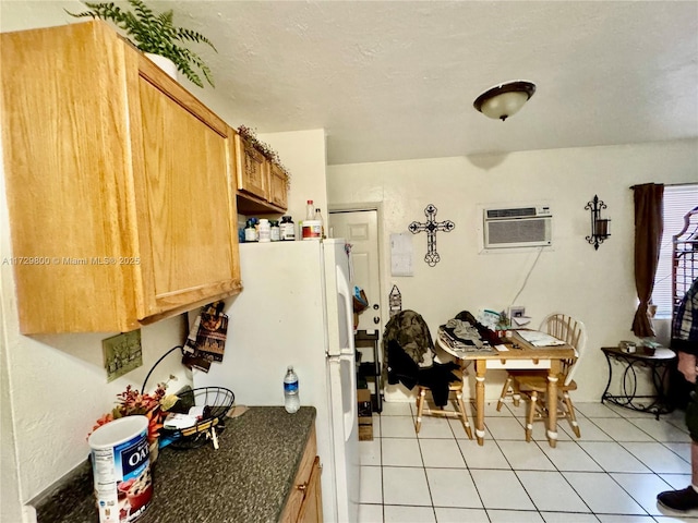 kitchen with light tile patterned floors, a wall mounted AC, and white fridge