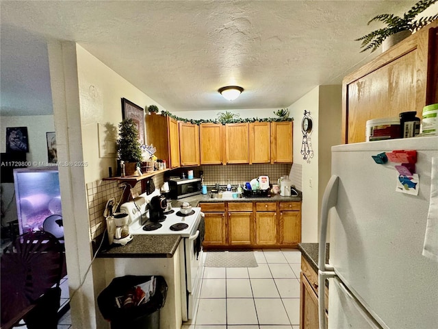 kitchen with tasteful backsplash, white appliances, a textured ceiling, and light tile patterned flooring