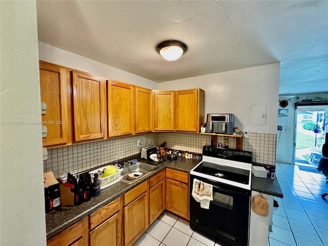 kitchen featuring backsplash, sink, light tile patterned floors, and electric range