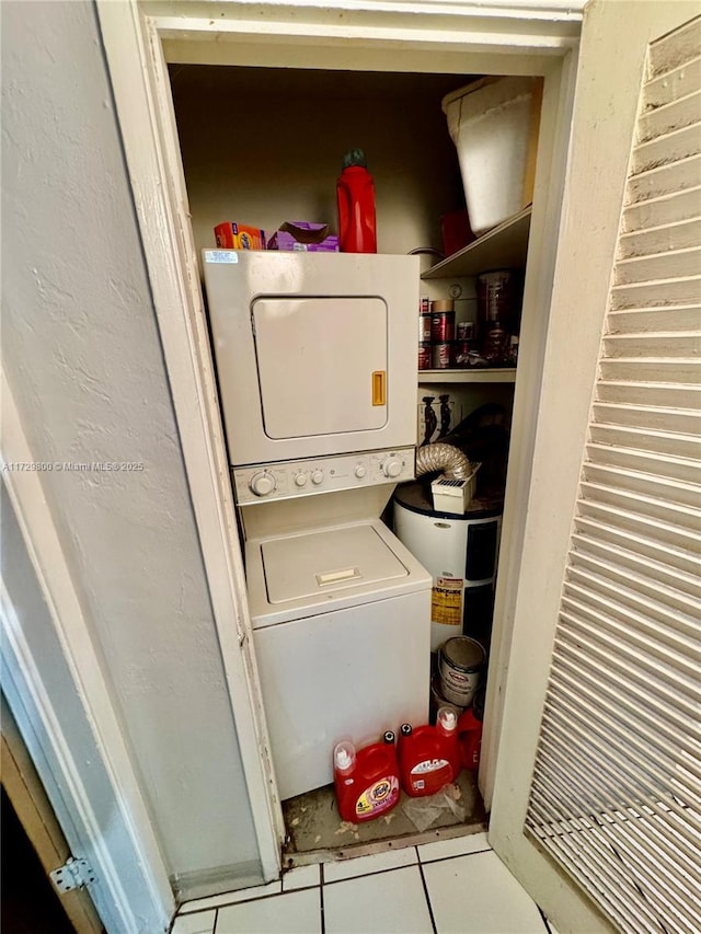 clothes washing area featuring stacked washer / drying machine and tile patterned floors