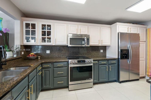 kitchen with white cabinetry, sink, backsplash, light tile patterned floors, and stainless steel appliances