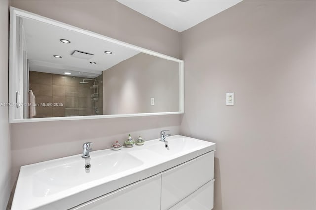 bathroom with vanity and a tile shower