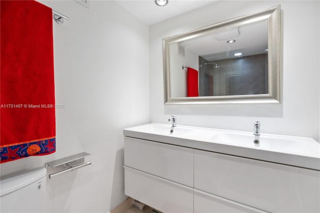 bathroom featuring vanity, toilet, and walk in shower