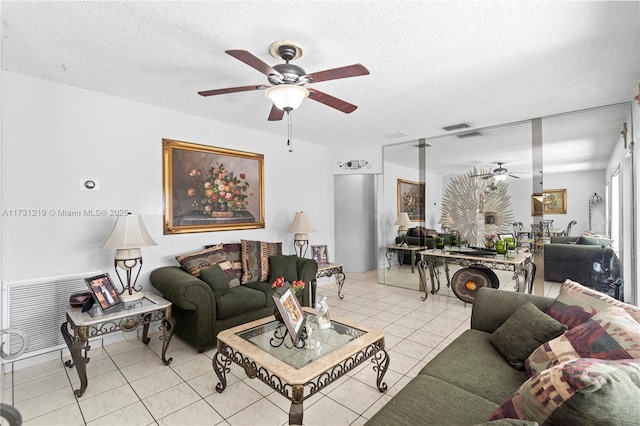 tiled living room with ceiling fan and a textured ceiling