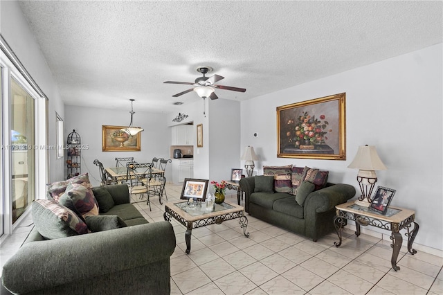 living room featuring ceiling fan and a textured ceiling