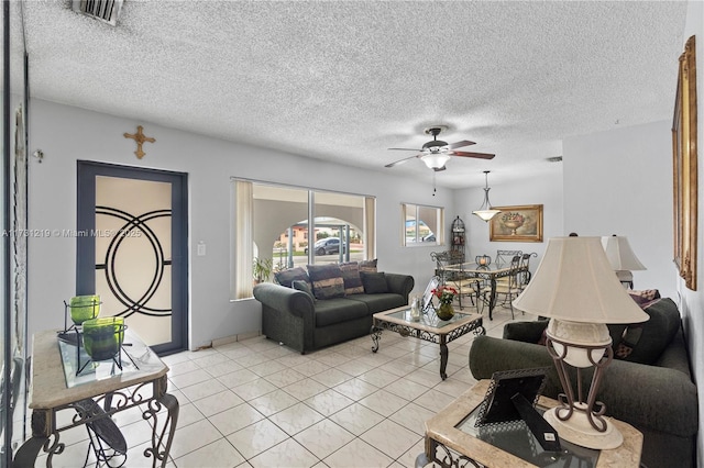 living room featuring light tile patterned floors, a textured ceiling, and ceiling fan