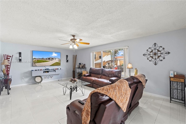 living room featuring ceiling fan, a textured ceiling, and light tile patterned floors