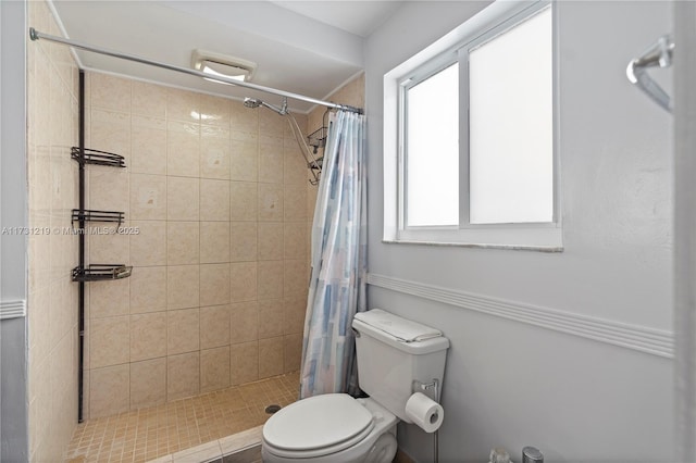 bathroom featuring a shower with curtain, a wealth of natural light, and toilet